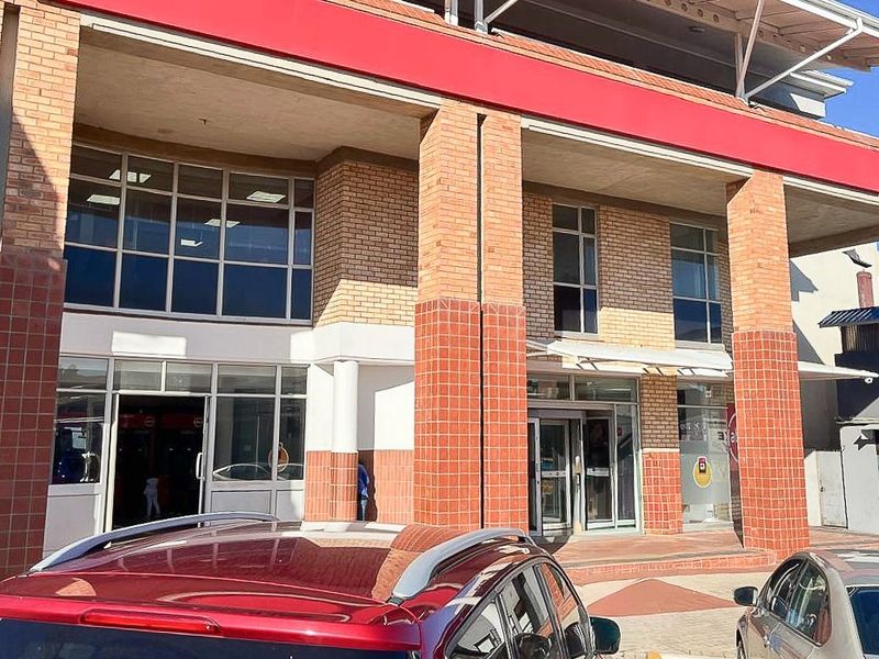 Front elevation of a commercial retail building featuring brick masonry, large glass storefront windows, and a prominent entrance area.