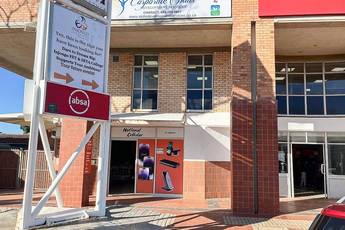 Front exterior view of a commercial retail building featuring brick masonry, large aluminium windows, and prominent signage for multiple business tenants.