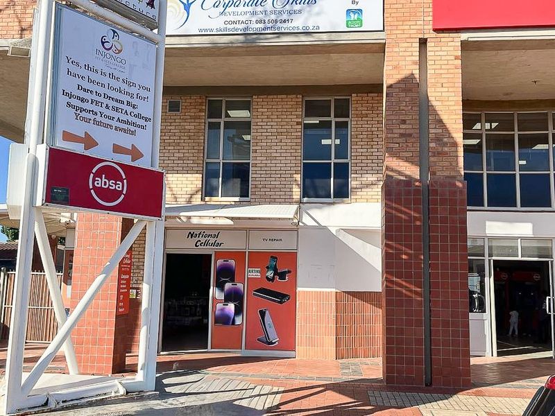 Front exterior view of a commercial retail building featuring brick masonry, large aluminium windows, and prominent signage for multiple business tenants.