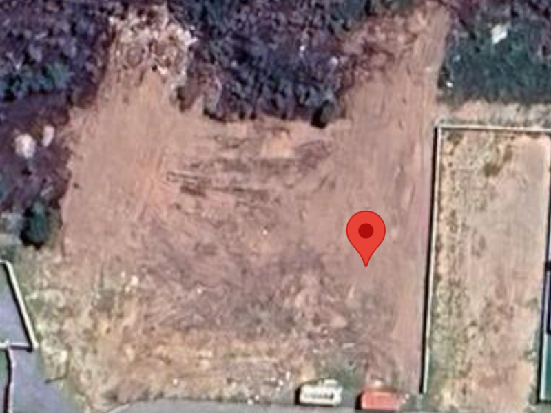 Aerial view of a vacant residential plot showing cleared land and boundary fencing.