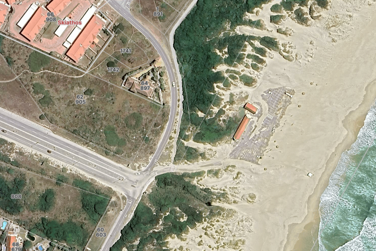 Aerial view of the coastal residential area showing proximity to the beach, surrounding road infrastructure, and natural dune landscape.