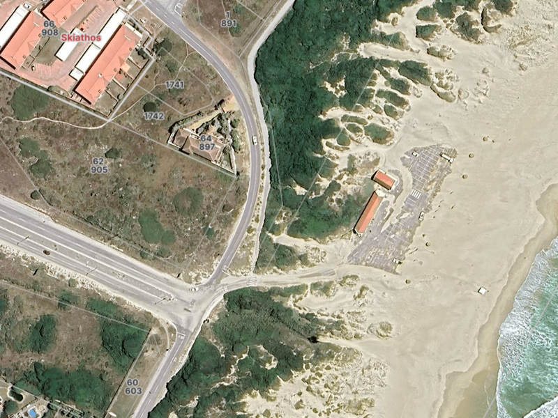 Aerial view of the coastal residential area showing proximity to the beach, surrounding road infrastructure, and natural dune landscape.
