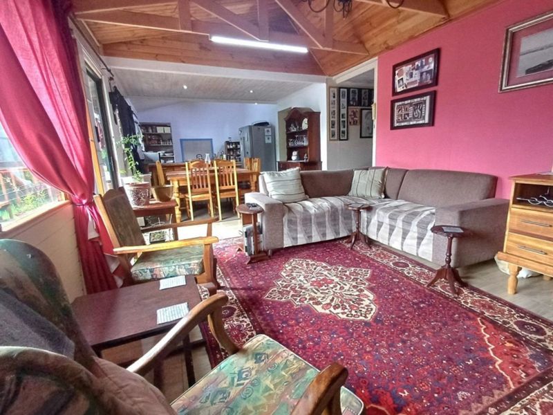 Open plan living and dining area featuring exposed timber ceilings and laminate flooring with direct access to the outdoor area.