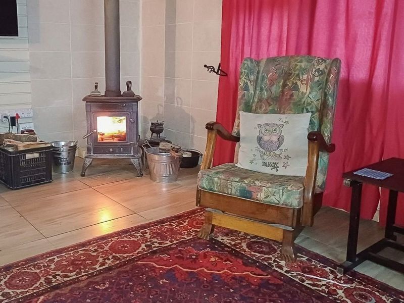 A cozy living room area featuring a traditional cast iron fireplace and tiled flooring.