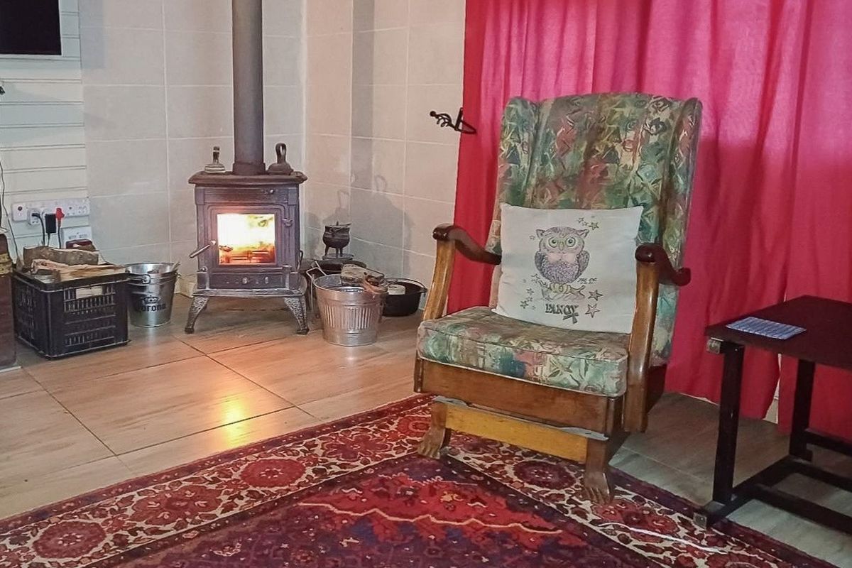 A cozy living room area featuring a traditional cast iron fireplace and tiled flooring.