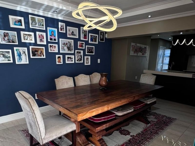 A well-appointed dining room featuring tiled flooring, crown molding, and a modern pendant light, creating an inviting space for formal meals.