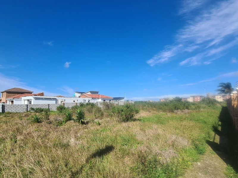 A vacant residential plot featuring established boundary walls and electric fencing, situated in a developed neighborhood.