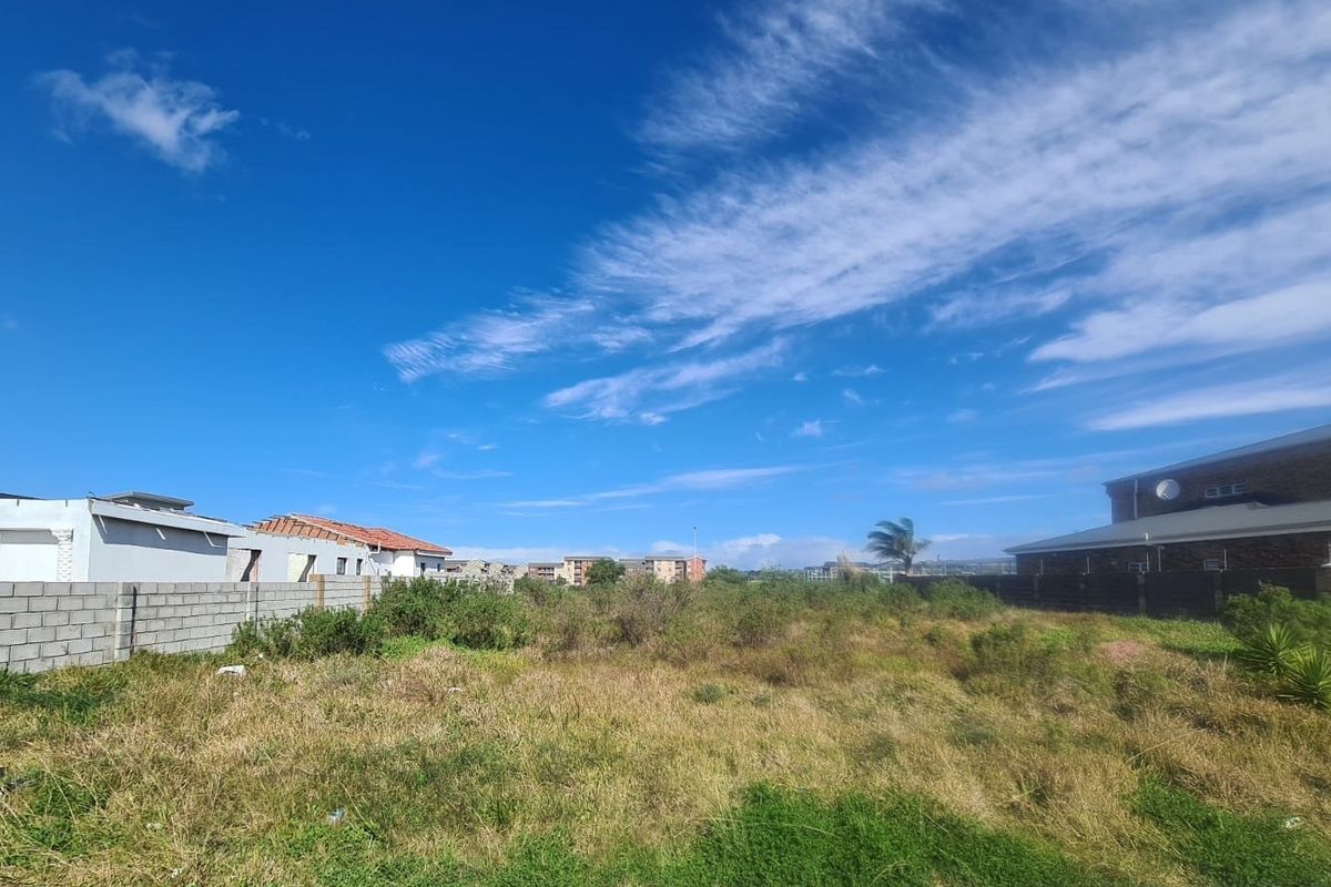 A vacant residential plot featuring a perimeter boundary wall, offering a clear space ready for development within an established neighborhood.