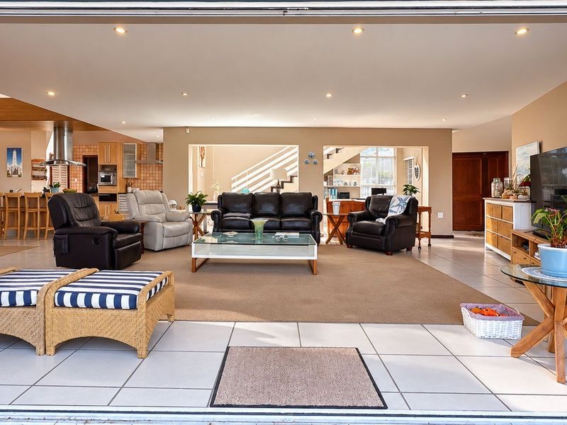 Spacious open-plan living area featuring tiled floors, recessed lighting, and a seamless transition to the kitchen, creating a bright and functional family space.