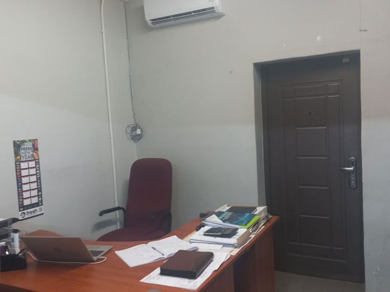 A functional office space featuring a wall-mounted air conditioning unit and a standard interior door.