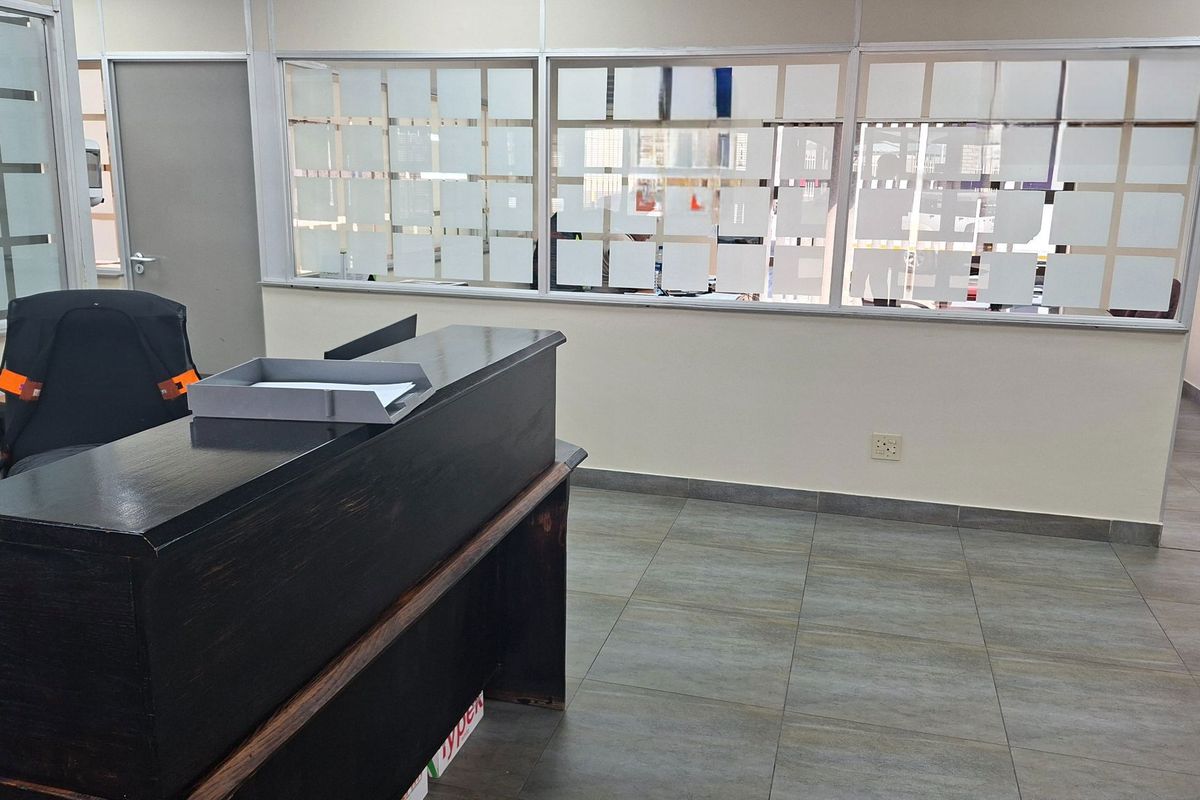 A functional office space featuring tiled flooring and partitioned glass walls, providing a professional environment suitable for administrative or industrial operations.