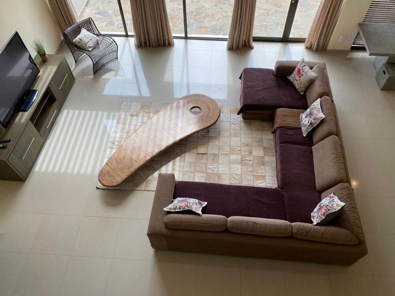 Spacious living area featuring large format floor tiles and expansive sliding glass doors providing seamless access to the outdoor patio area.