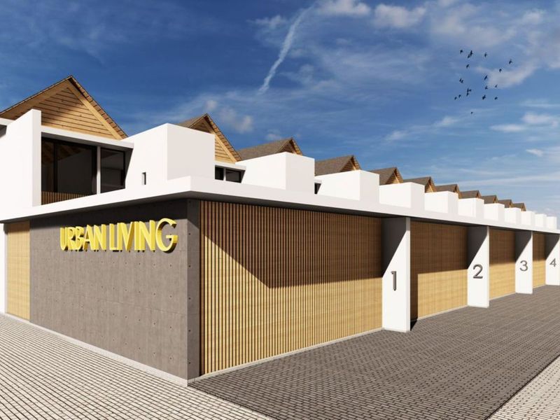 A modern townhouse development featuring a row of garages with timber slat detailing and concrete facade elements.