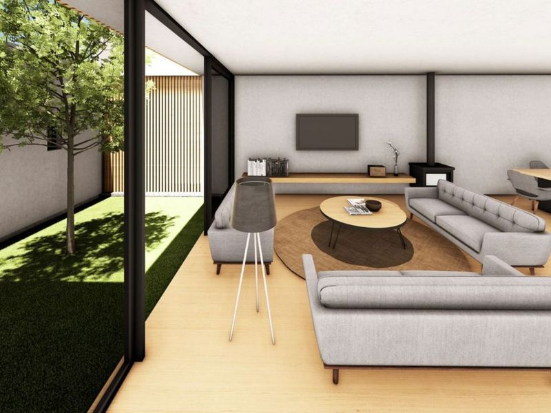 Modern open-plan living and dining area featuring timber flooring, a fireplace, and seamless indoor-outdoor flow through large sliding glass doors to a private garden.