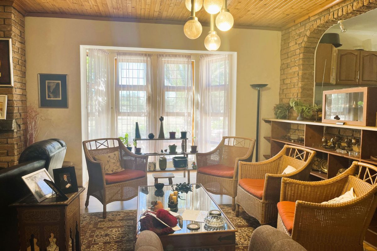 A cozy living room featuring exposed brick walls, a timber ceiling, and a built-in brick archway, offering a rustic and character-filled atmosphere.