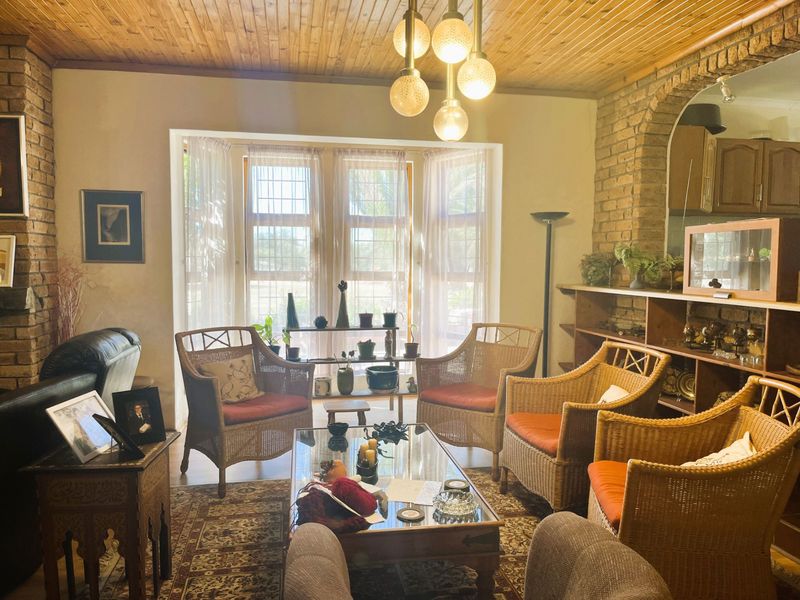 A cozy living room featuring exposed brick walls, a timber ceiling, and a built-in brick archway, offering a rustic and character-filled atmosphere.