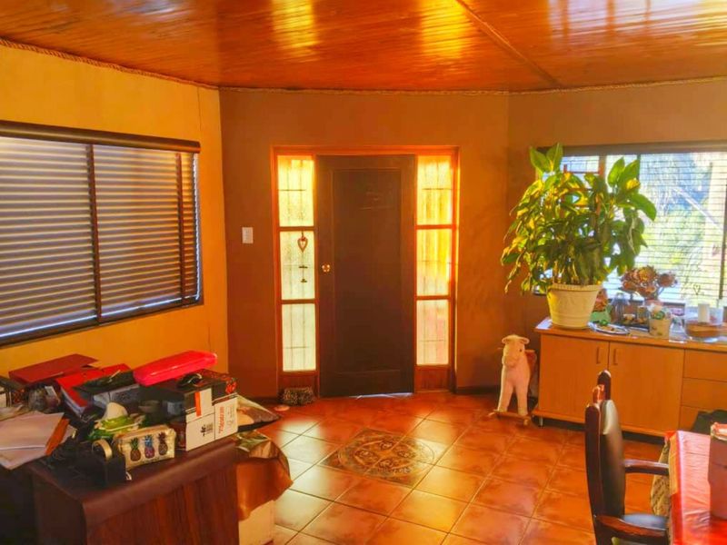 Entrance area featuring tiled flooring with a decorative inlay, timber ceiling, and a solid timber door with glass sidelights.