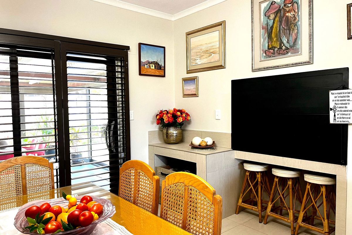 Living area featuring a built-in tiled bar counter, tiled flooring, and sliding glass doors providing access to the outdoor patio area.