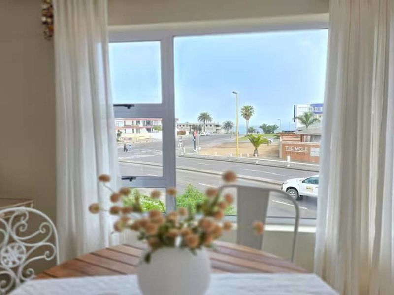 A bright living area featuring a large picture window that provides natural light and a view of the street and surrounding neighborhood.