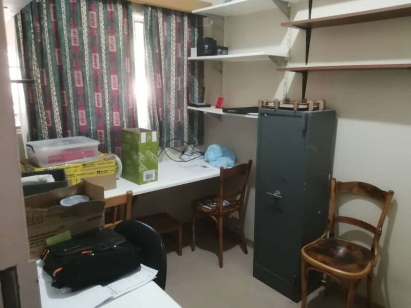 A small home office space featuring a built-in desk and wall-mounted shelving units.