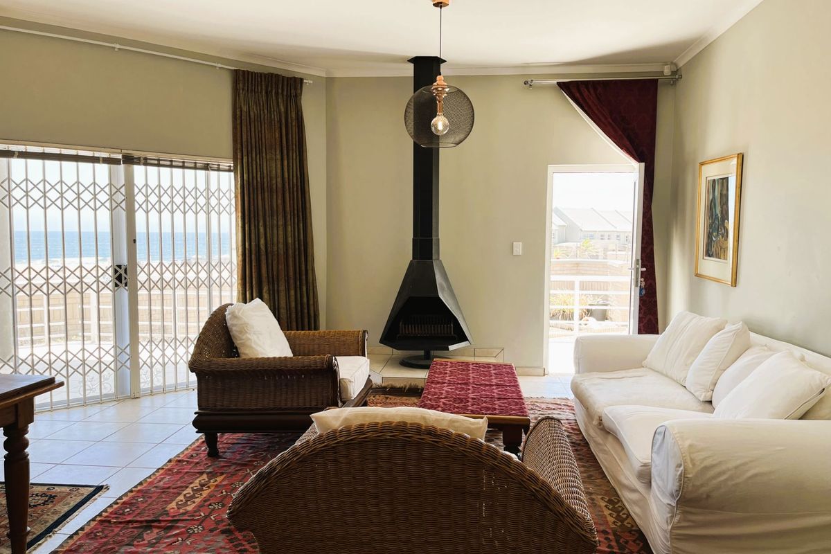 Spacious living room featuring a modern freestanding fireplace, tiled flooring, and large sliding glass doors providing access to the outdoor area.