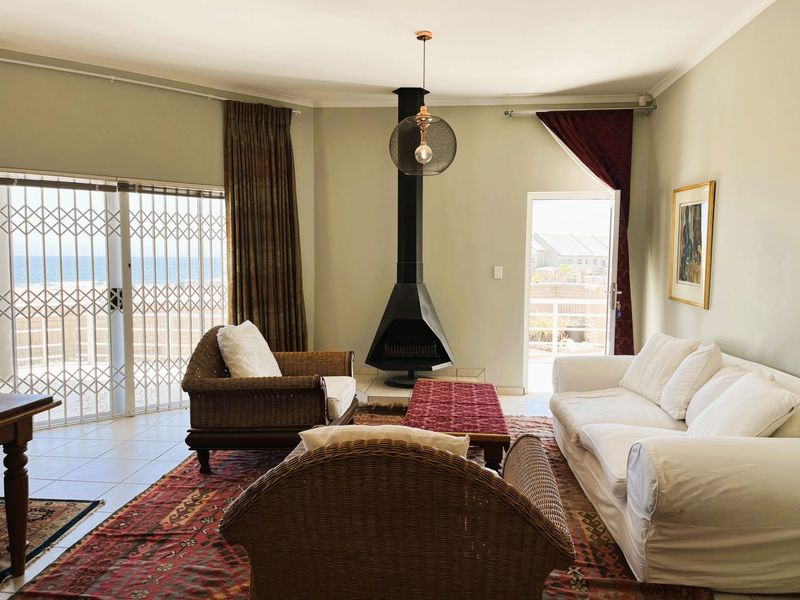 Spacious living room featuring a modern freestanding fireplace, tiled flooring, and large sliding glass doors providing access to the outdoor area.