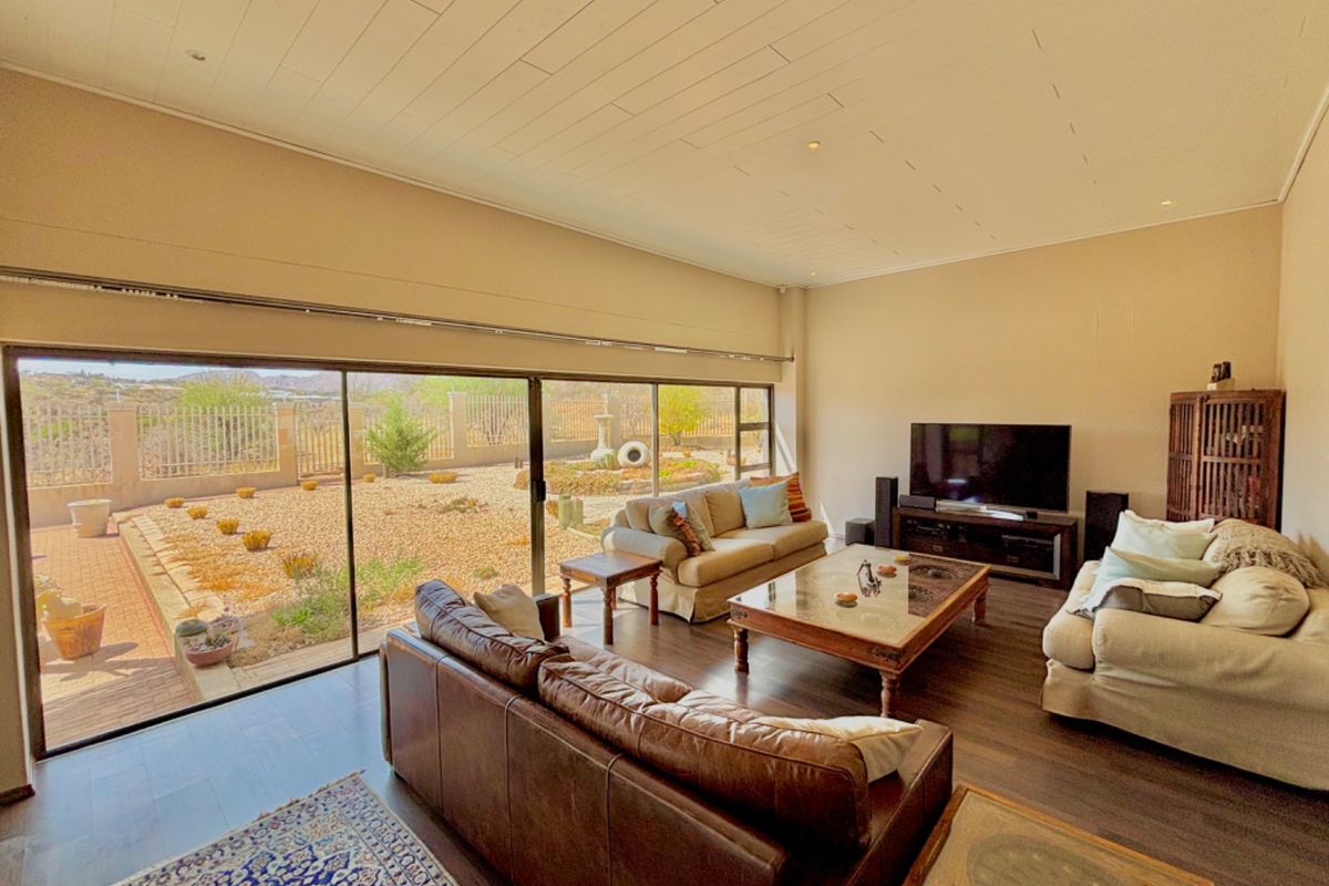 Spacious living room featuring large sliding glass doors that provide seamless access to the outdoor patio and garden area.