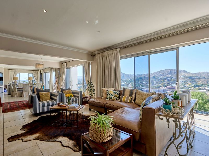 Spacious open-plan living and dining area featuring large sliding glass doors that offer expansive mountain views and abundant natural light.