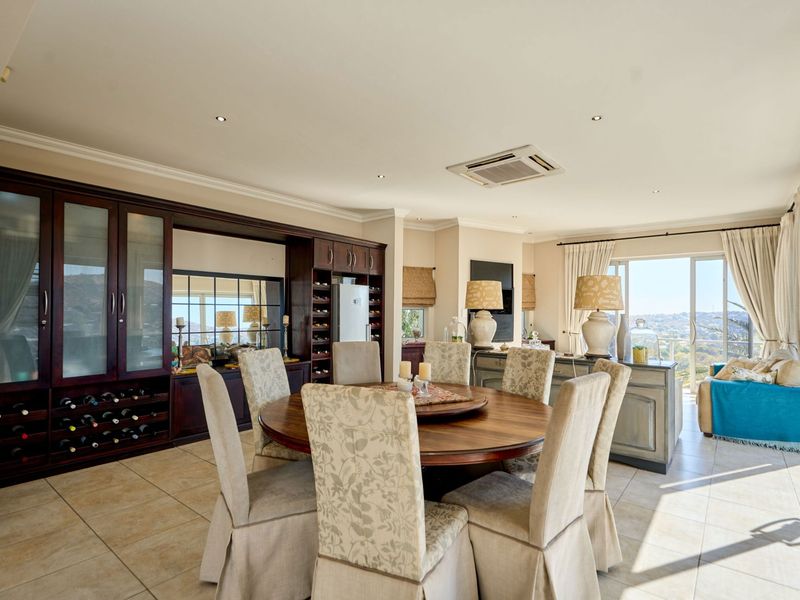 Spacious dining area featuring built-in wine storage, cabinetry, tiled flooring, and large sliding doors leading to an outdoor view.