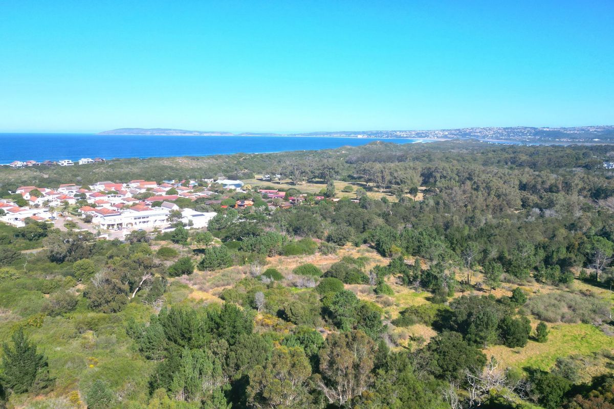 An aerial view of the residential land, showcasing the surrounding coastal landscape, natural vegetation, and proximity to the ocean.