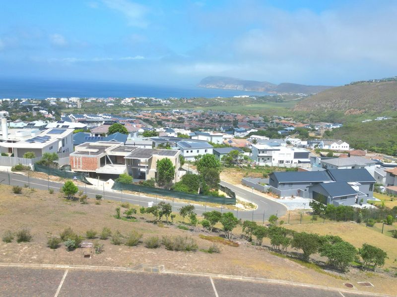 An elevated aerial view of a residential neighborhood and coastal landscape, showcasing the surrounding community and local topography.