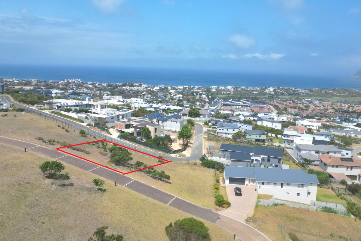 An aerial view of a vacant residential plot in a coastal estate, highlighting the land boundaries and surrounding neighborhood infrastructure.