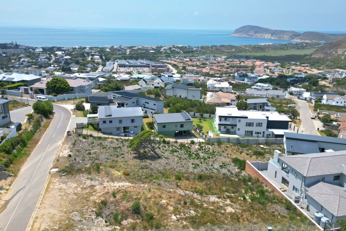 Aerial view of a vacant residential plot situated within an established coastal neighborhood, offering potential for development with scenic ocean views.