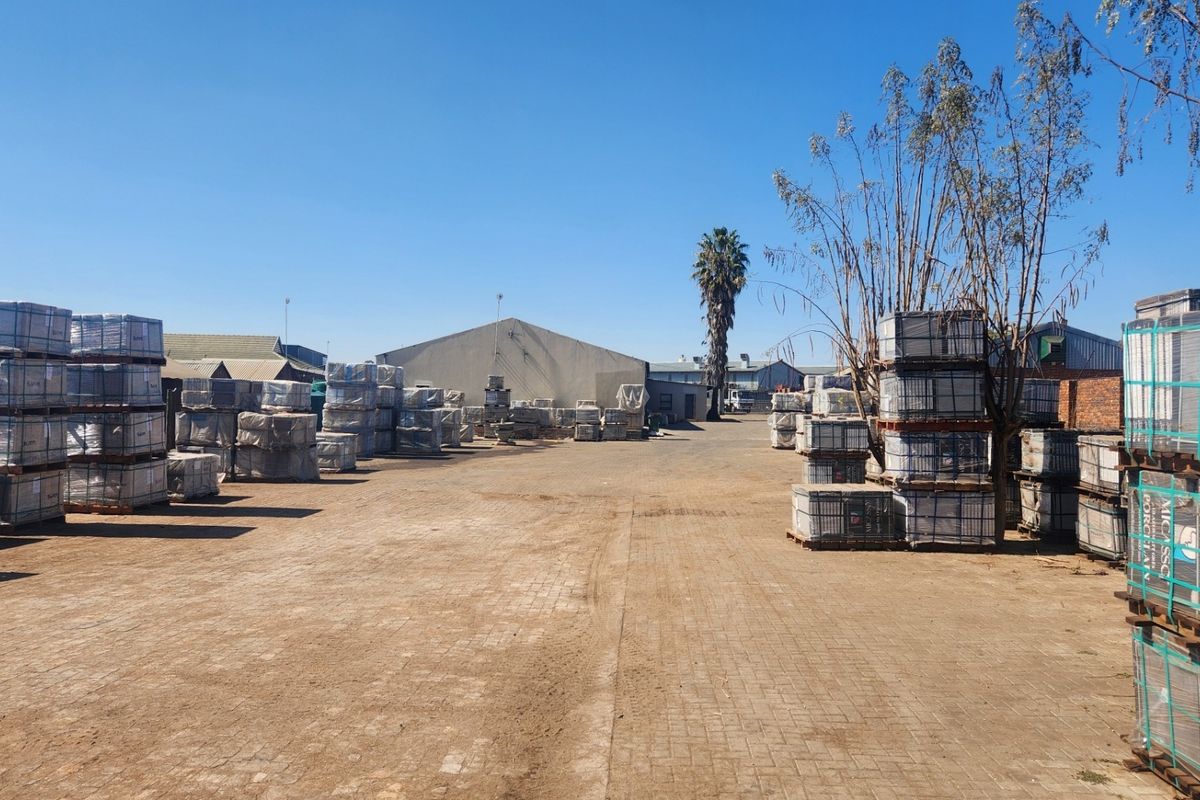 Spacious industrial yard area featuring paved ground surfaces and access to warehouse structures, suitable for storage or logistics operations.