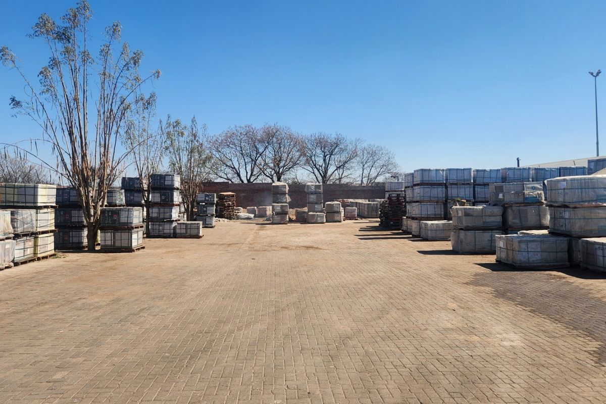 Spacious industrial paved yard area featuring perimeter walling and exterior lighting, suitable for storage or logistics operations.