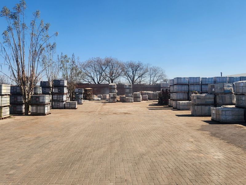 Spacious industrial paved yard area featuring perimeter walling and exterior lighting, suitable for storage or logistics operations.