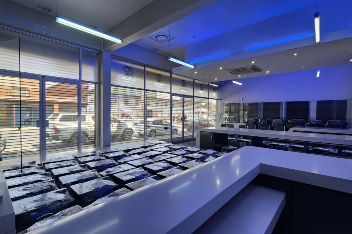 Modern retail space featuring a large service counter, extensive glass storefront windows, and integrated recessed lighting, suitable for a showroom or commercial display.