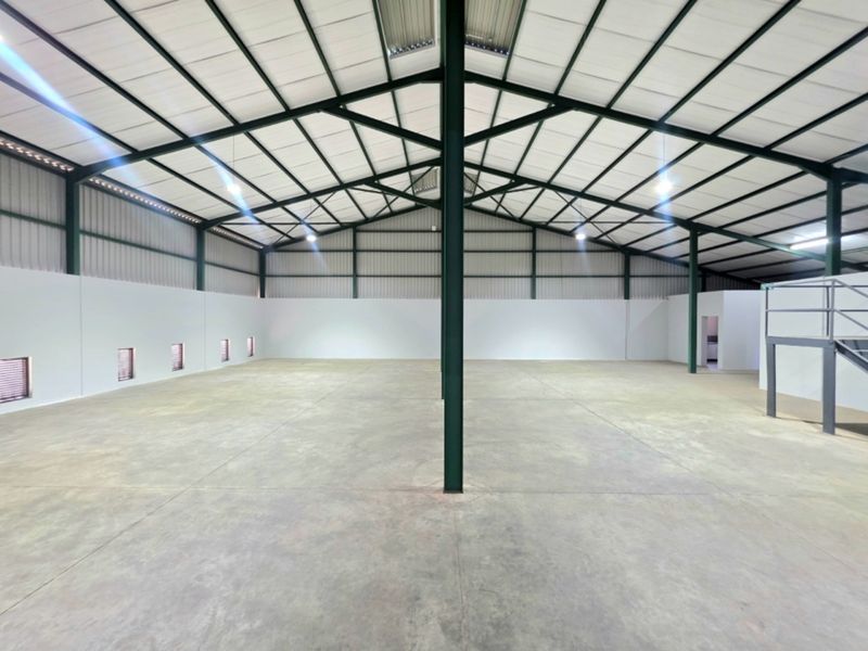 Spacious industrial warehouse featuring a high-clearance steel portal frame, polished concrete flooring, and an integrated mezzanine level.