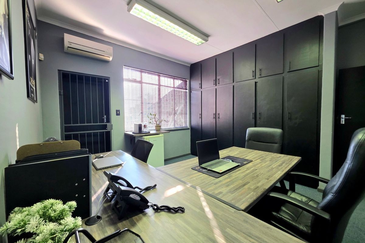 A professional office space featuring extensive built-in black cabinetry, air conditioning, and secure access, providing a functional and organized work environment.
