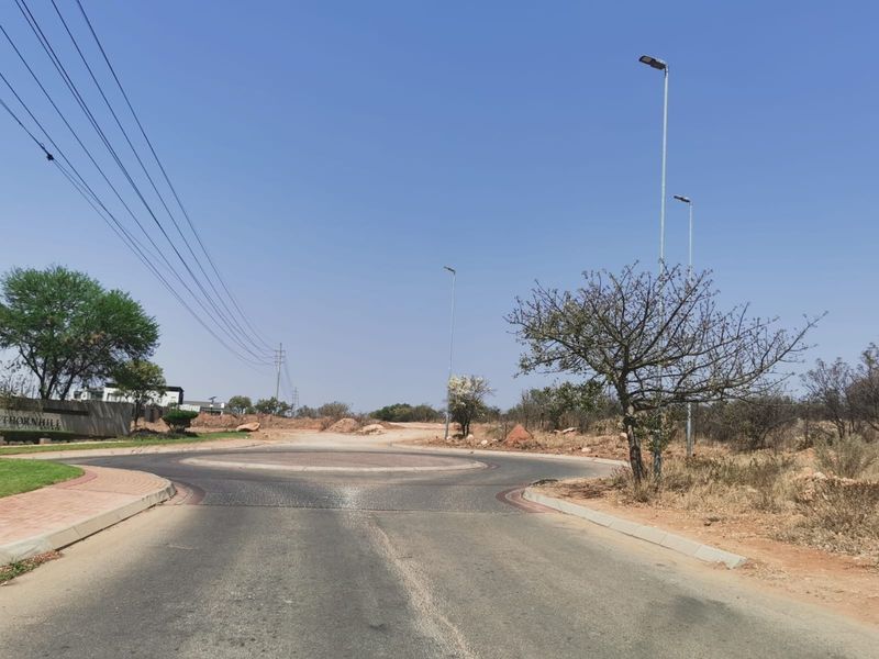 A view of a paved roundabout and street infrastructure within a commercial estate development.