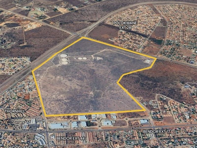 An aerial view of a large, undeveloped commercial land parcel situated near established residential and commercial zones in Polokwane.