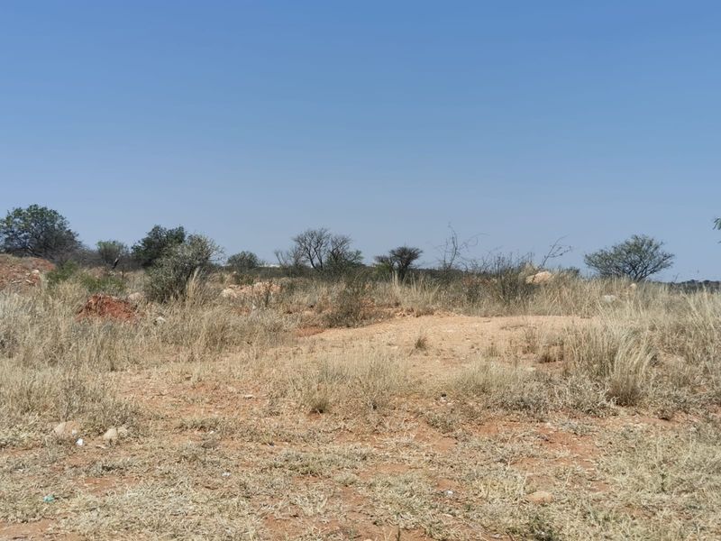 A view of the vacant commercial land featuring natural vegetation and open terrain.