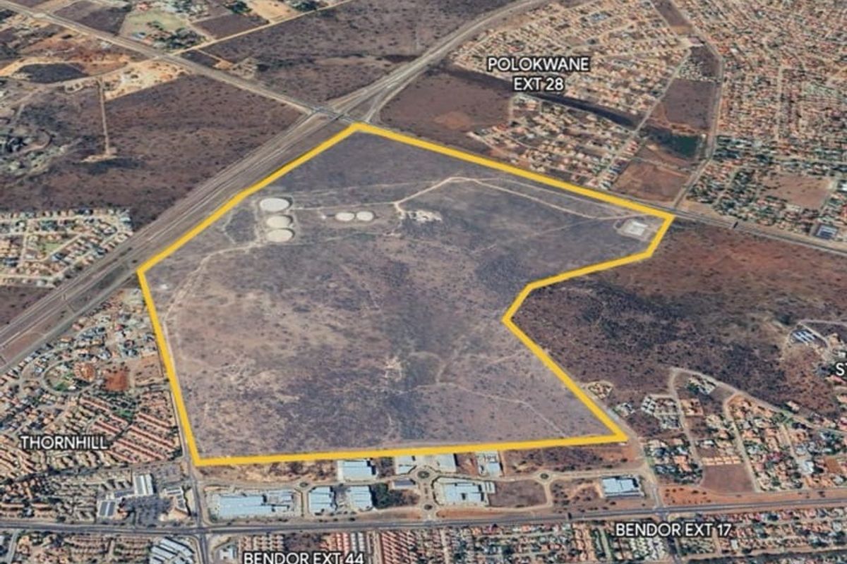 An aerial view of a large, undeveloped commercial land parcel situated near established residential and commercial zones in Polokwane.