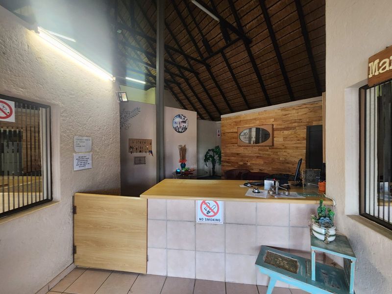 Reception area featuring a thatched roof, timber wall accents, and a tiled service counter, providing a rustic welcome to the property.