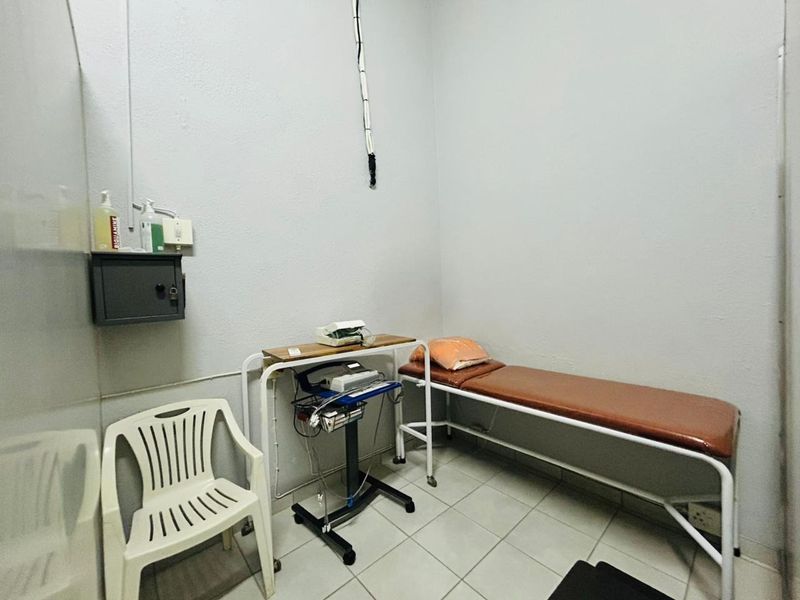A functional clinical utility space featuring tiled flooring and wall-mounted storage, suitable for medical or professional use.