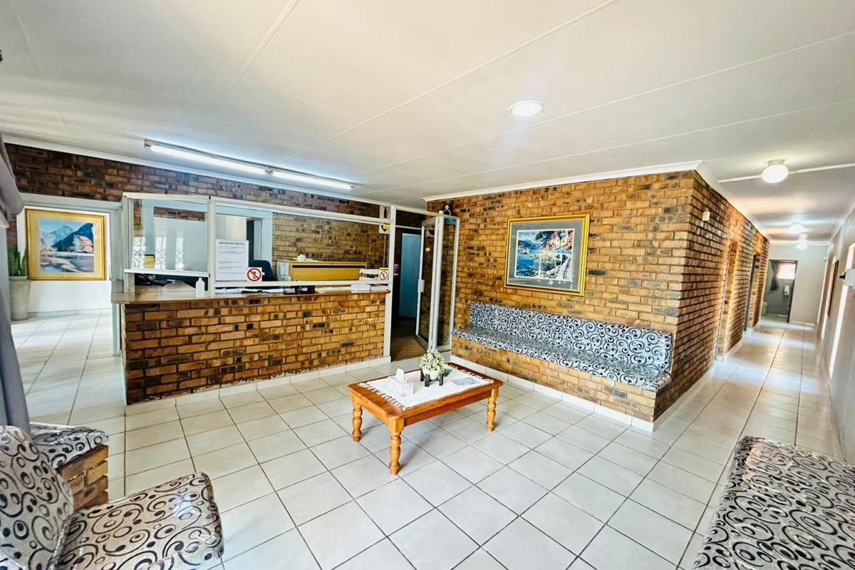 Commercial reception area featuring a brick feature wall, built-in reception desk, integrated bench seating, and ceramic tile flooring.