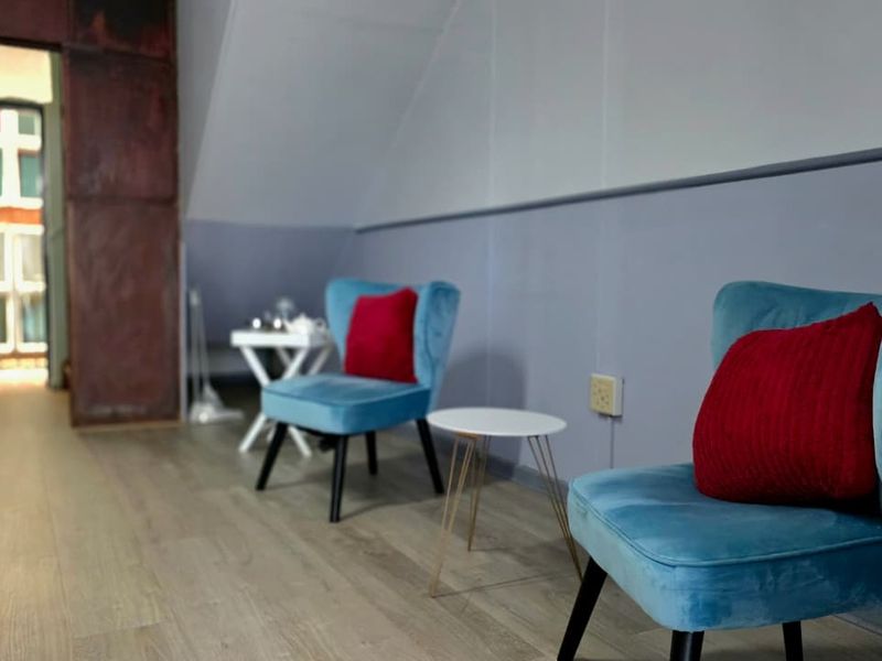 A compact office space featuring laminate flooring and a sloped ceiling, providing a functional area for professional use.