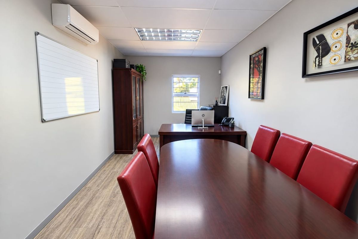 A professional office space featuring laminate wood flooring, recessed lighting, and a wall-mounted split-system air conditioner.