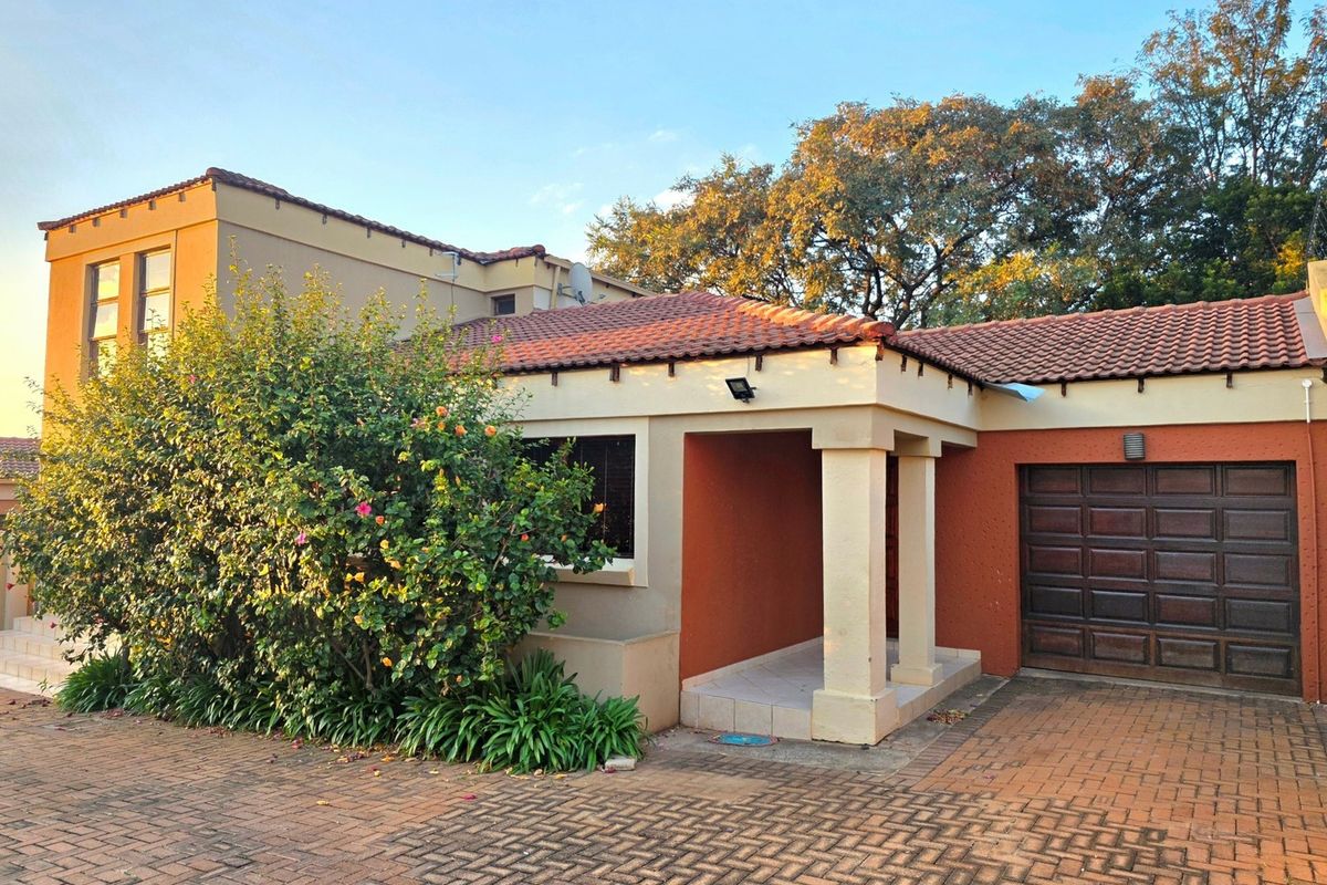 Front elevation of a residential house featuring a paved driveway, covered entrance, and integrated garage with a tiled roof.