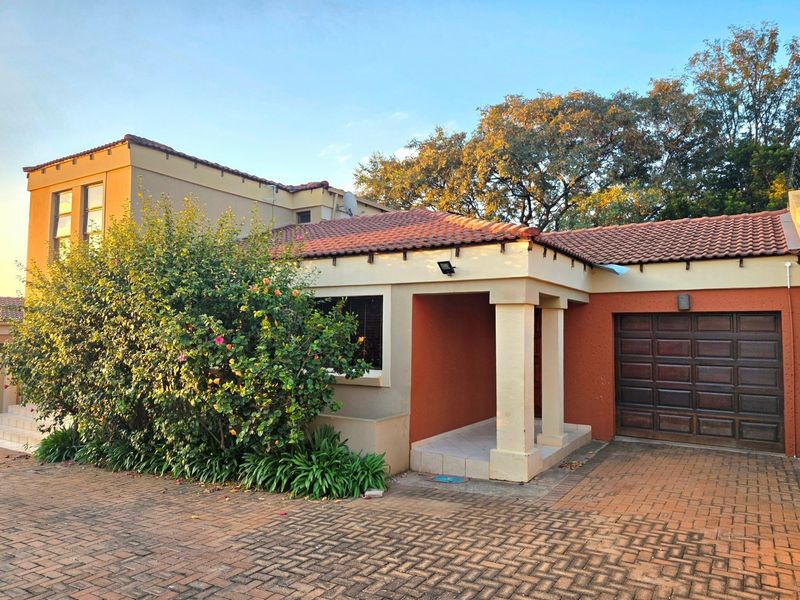 Front elevation of a residential house featuring a paved driveway, covered entrance, and integrated garage with a tiled roof.